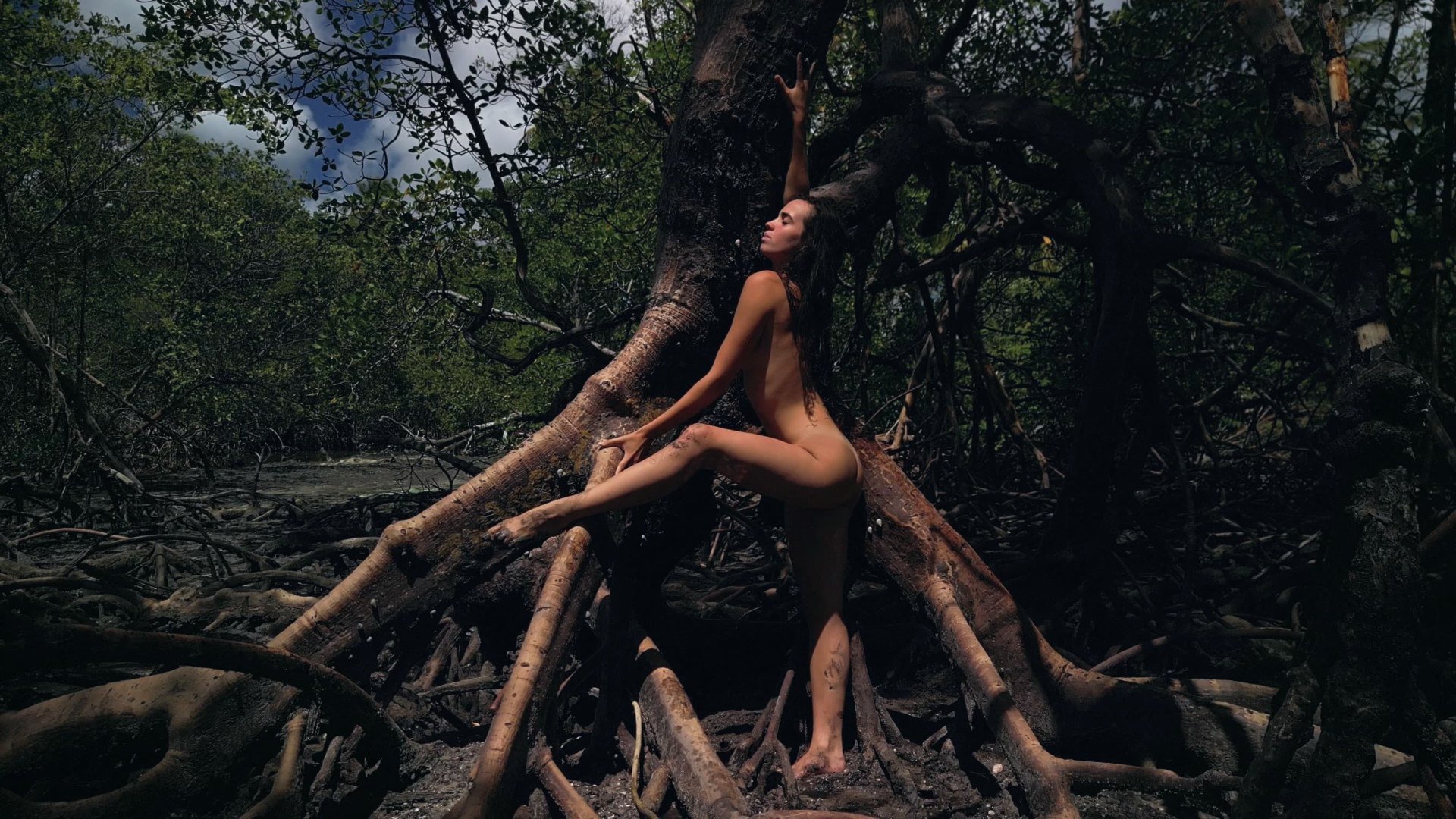 Luana em conexão com a natureza entre raízes de mangue